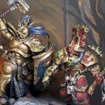 Diorama de Age of Sigmar representando un duelo entre un Stormcast Eternals dorado con martillo y un guerrero de Khorne con armadura roja. Miniaturas pintadas y fotografiadas por Kike Herrero sobre una base escénica detallada con calaveras, rocas y fondo de fuego.