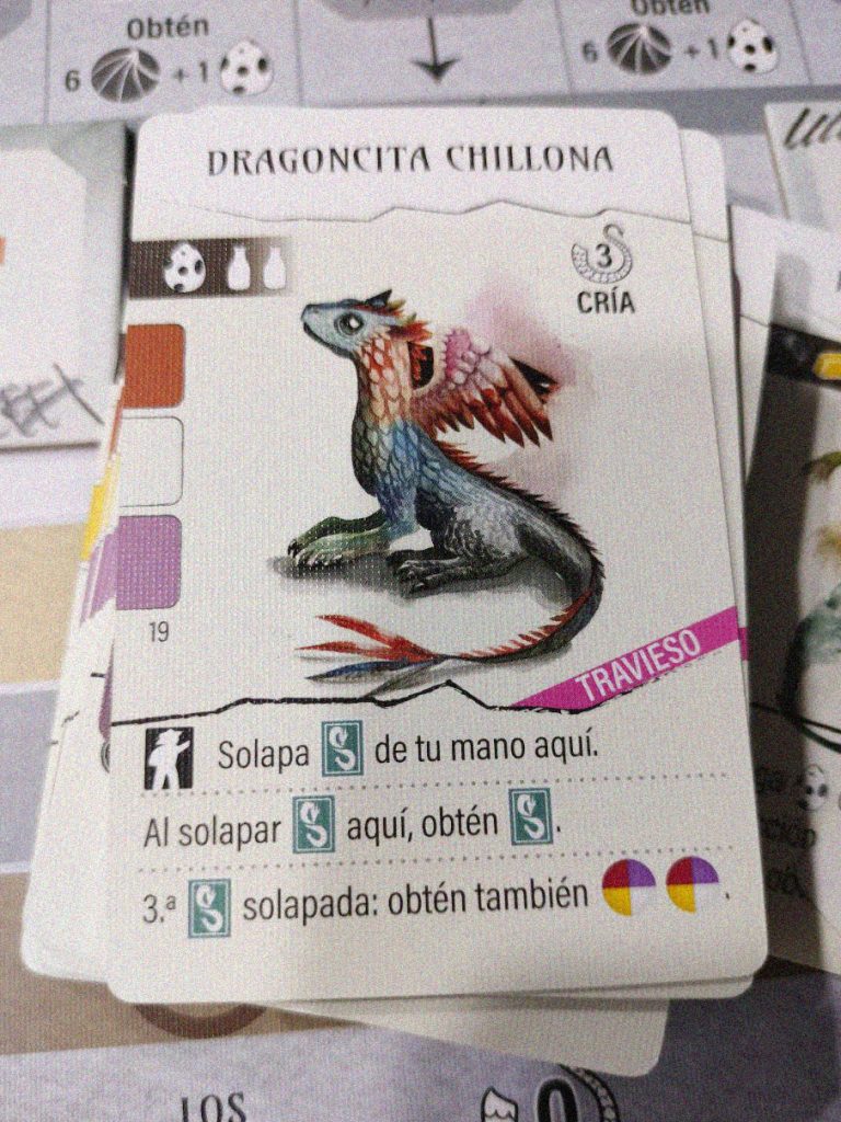 Carta de Wyrmspan con la ilustración de la “Dragoncita Chillona”, un dragón bebé de colores brillantes.