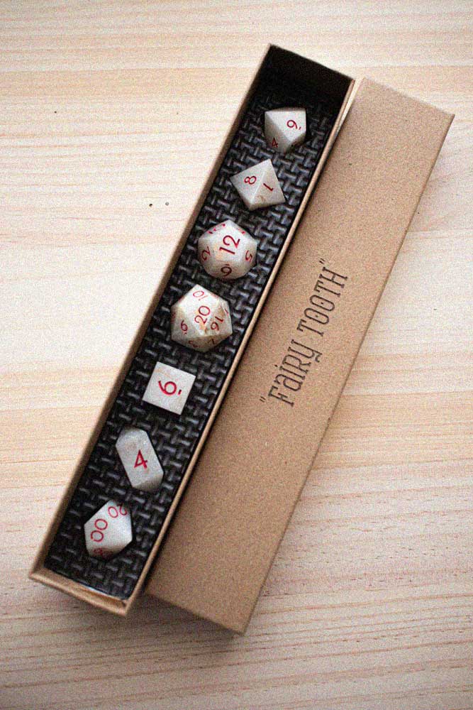 Set de dados artesanales “Fairy Tooth” de Gnomish Crafts en su caja