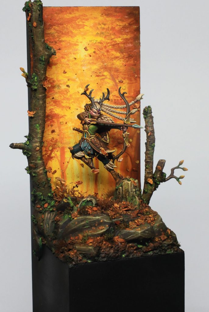 Vista lateral de la viñeta de Qulathis pintada por Javi Lozano, con composición vertical y efectos de bosque otoñal