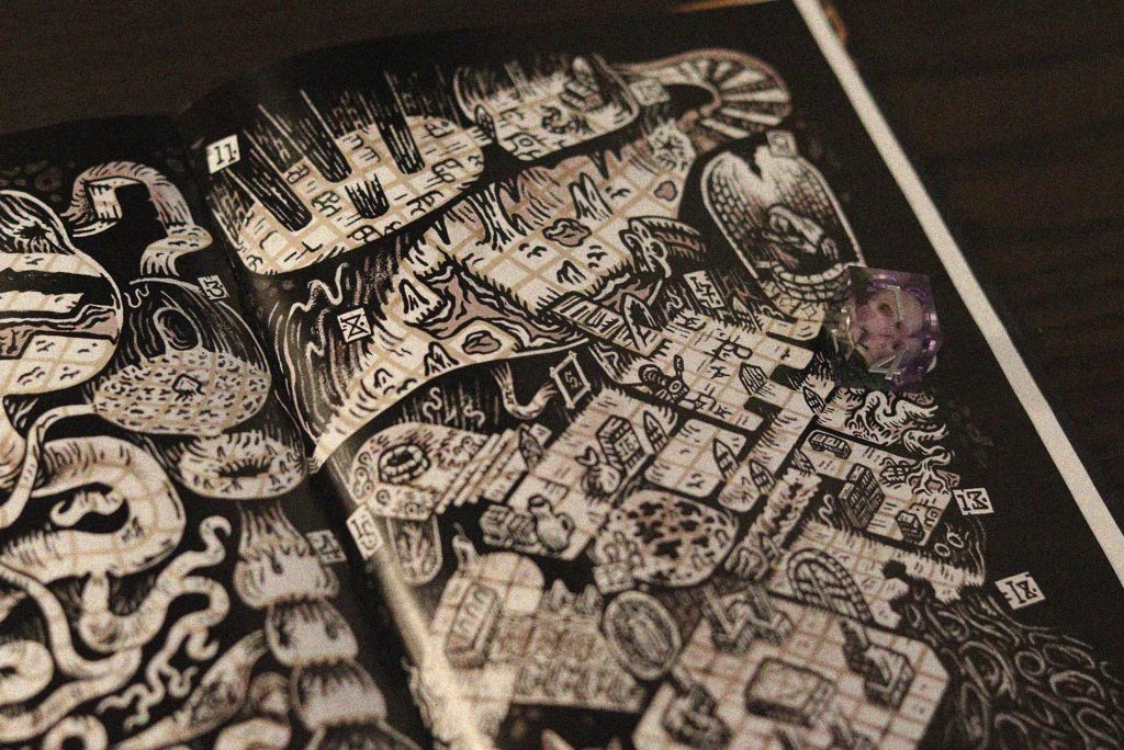 Ilustración del mapa interno de Pobladores de un Dios Muerto en blanco y negro, acompañada por un dado púrpura sobre la página.