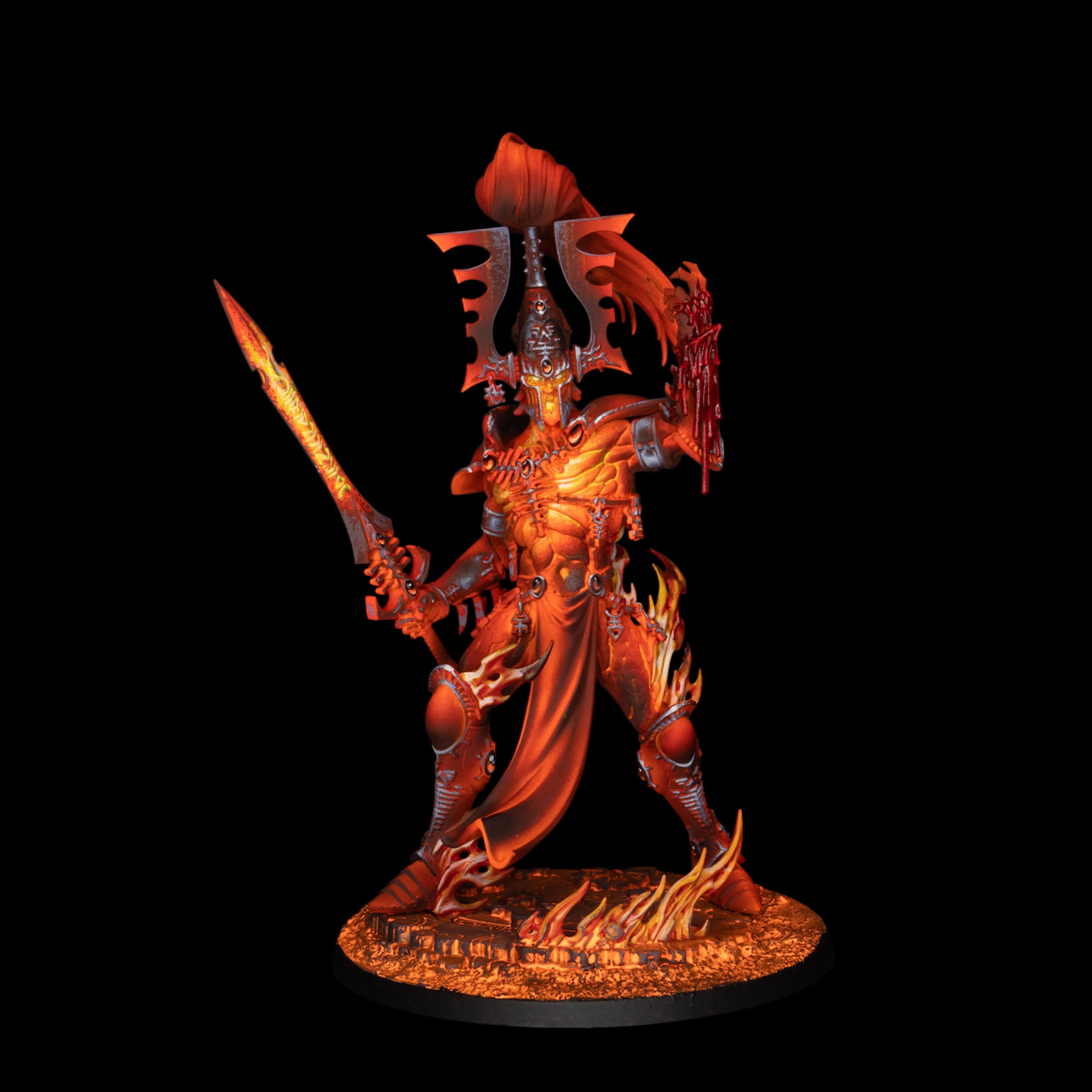 Miniatura de Warhammer 40k pintada por Daniel Vallejo, guerrero eldar envuelto en llamas con espada incandescente sobre fondo negro.