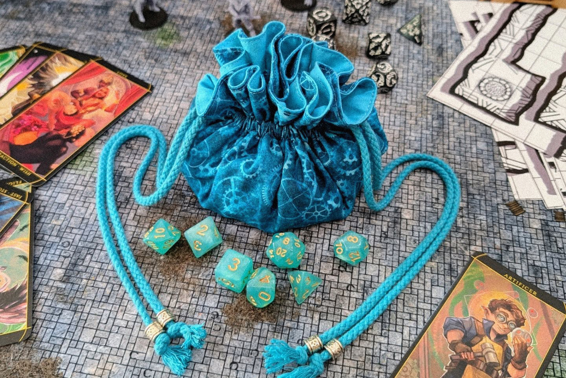 saquito de dados artesanal azul de Costurero Rolero sobre mesa de juego de rol con dados y cartas