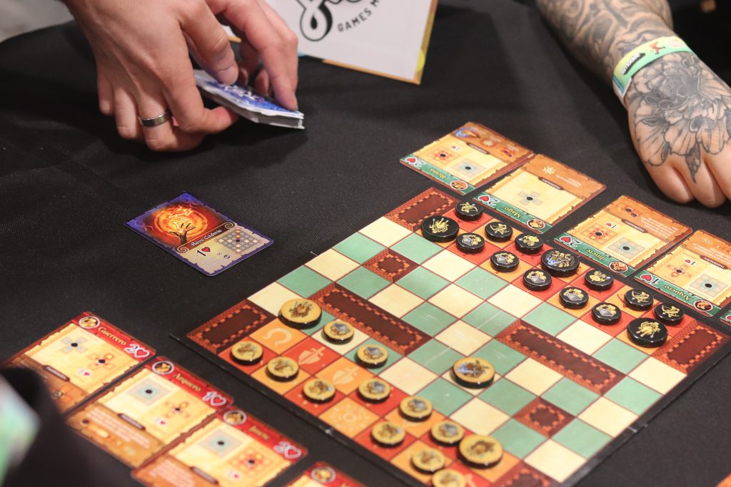 Jugador realizando una jugada en Tenacy con ambos ejércitos enfrentados en el tablero