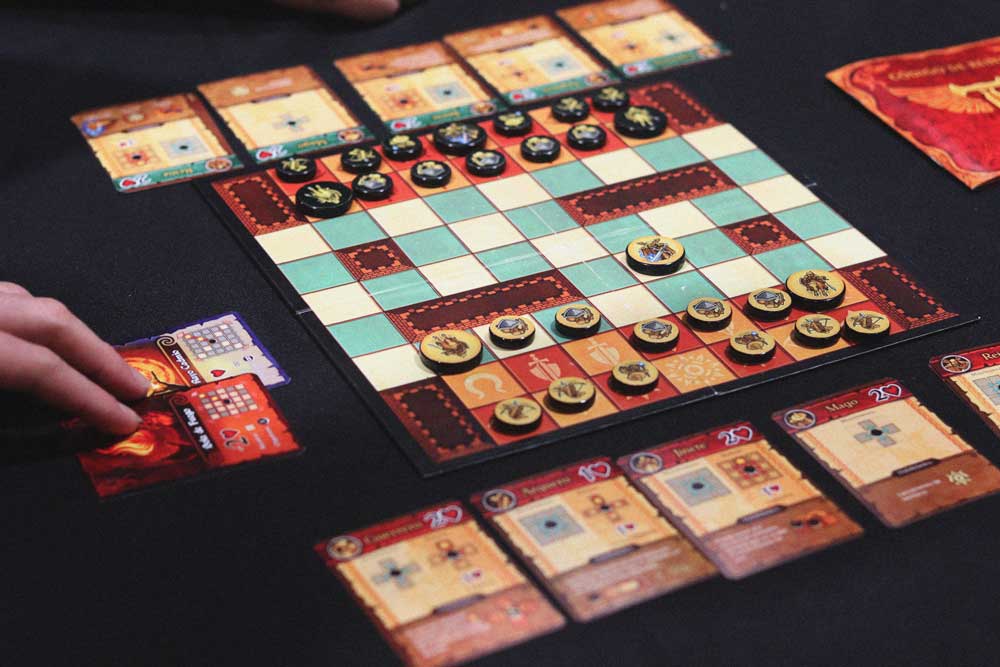 Jugador robando una carta en Tenacy con el tablero desplegado durante la partida