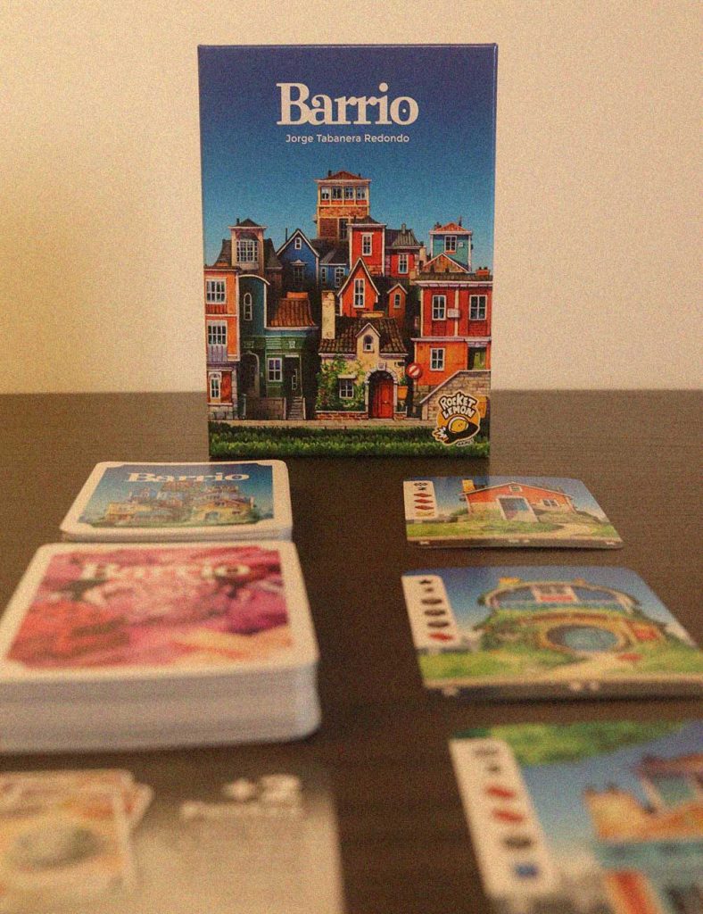 Caja del juego de mesa Barrio con cartas dispuestas en la mesa durante una partida
