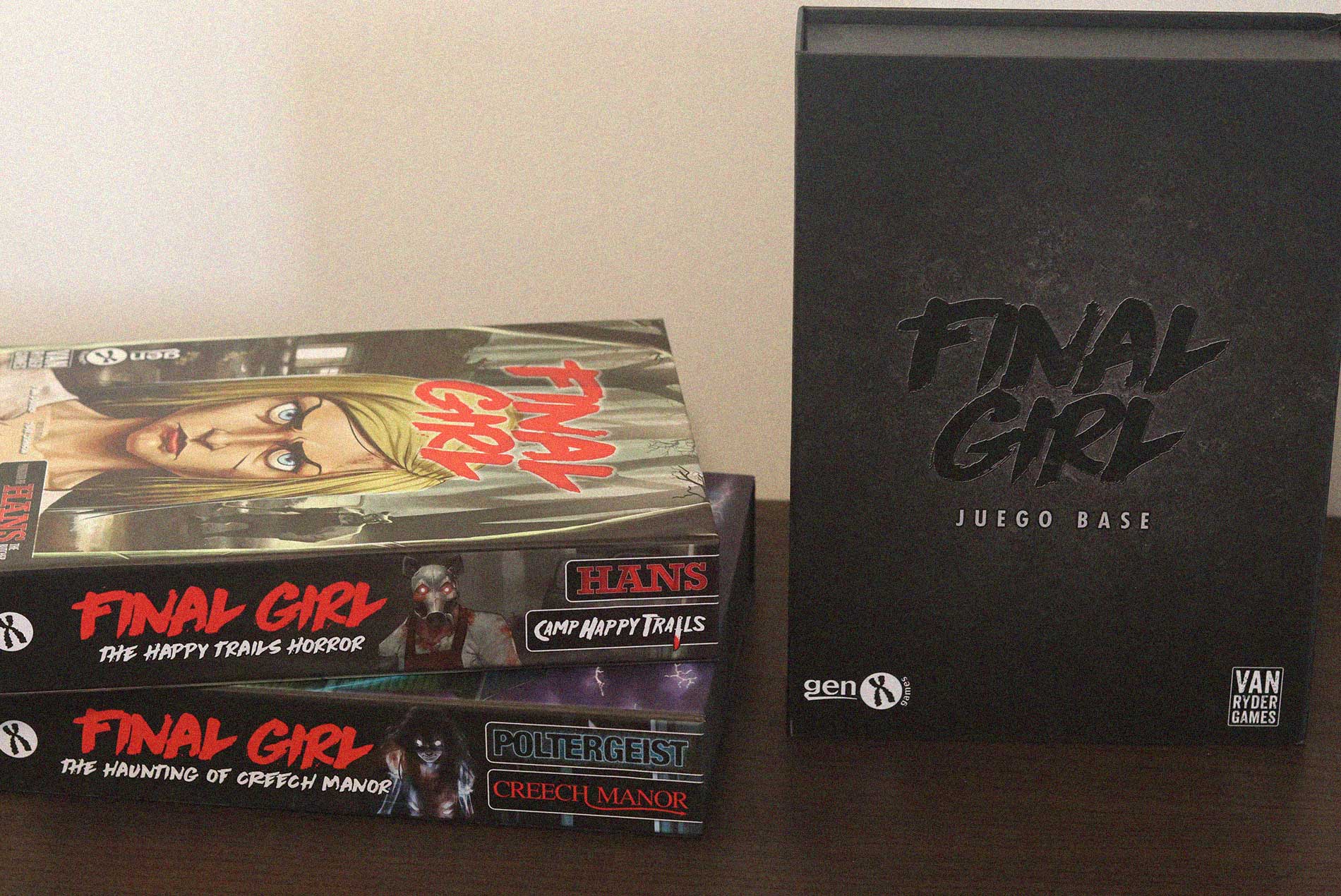 Cajas del juego de mesa Final Girl con el juego base y los largometrajes Camp Happy Trails y Creech Manor