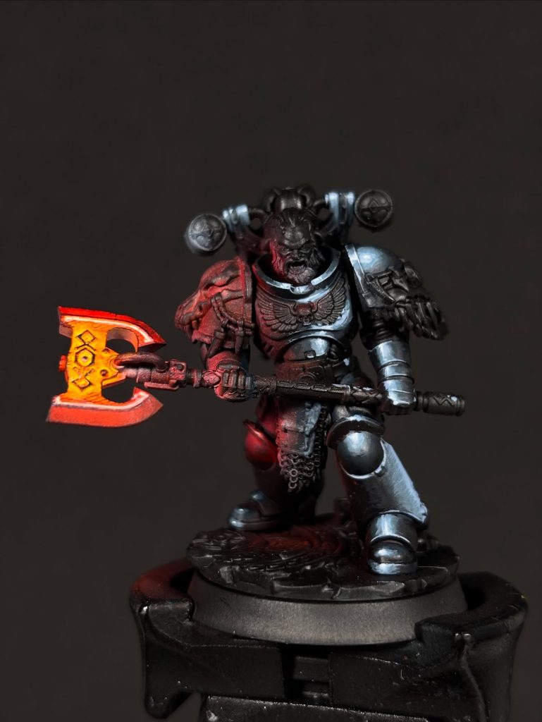 space marine con efecto de luz roja en arma en proceso de pintura