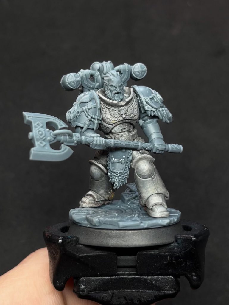 miniatura space marine con imprimación gris en proceso de pintura