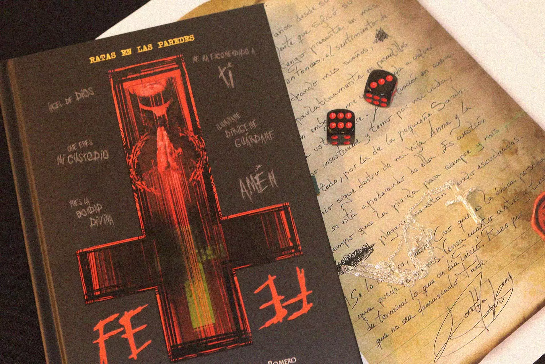 Portada de Fe junto a una carta manuscrita y dados sobre la mesa durante una partida de rol.