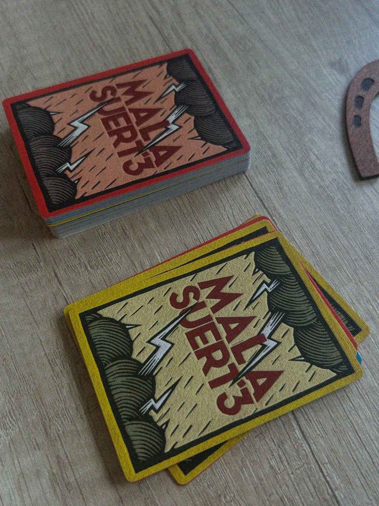 Cartas de Mala Suerte con el reverso del juego y una baraja sobre una mesa