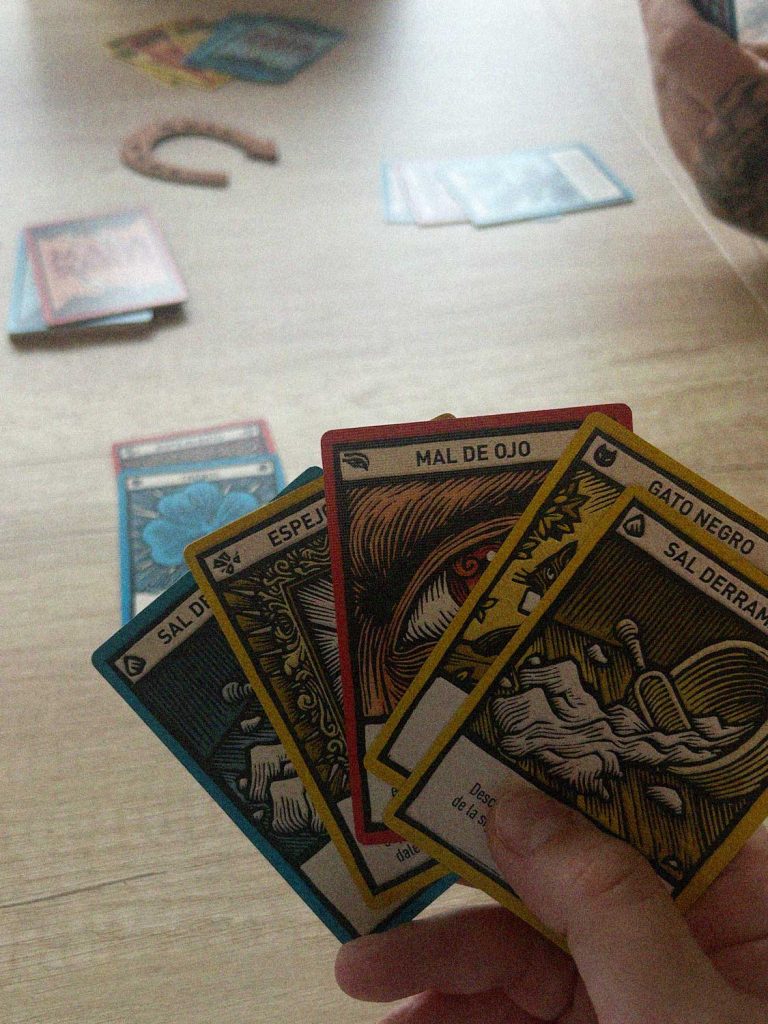 Partida de Mala Suerte con cartas de mal de ojo, gato negro, sal derramada y espejo roto