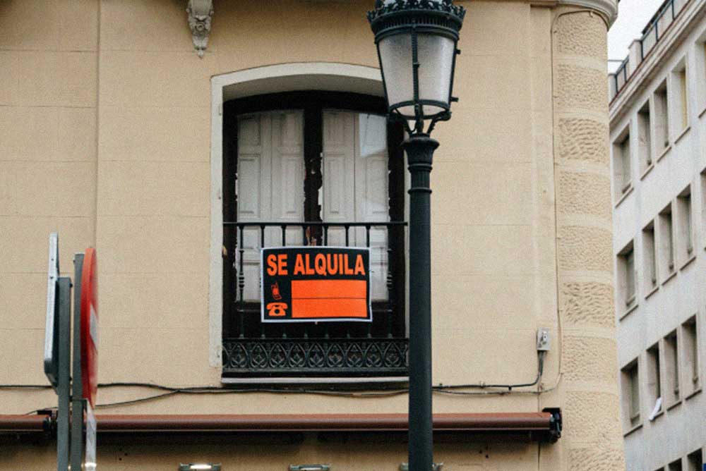 Cartel de «Se alquila» colocado en el balcón de un edificio.