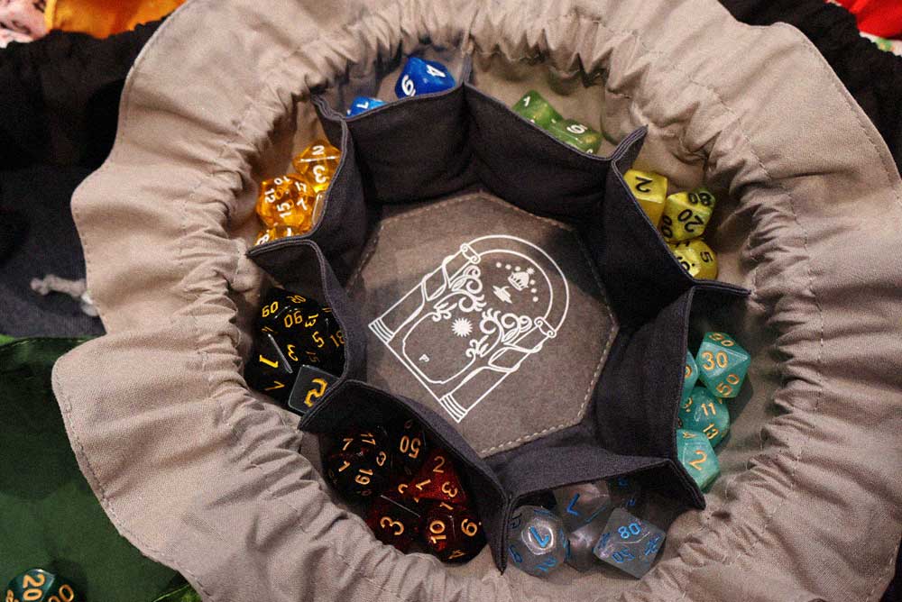 Saco de dados de Costurero Rolero con dados de rol de varios colores en su interior.