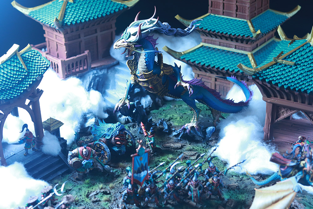 Diorama de miniaturas de inspiración oriental con un dragón azul y guerreros en Freak Wars 2026