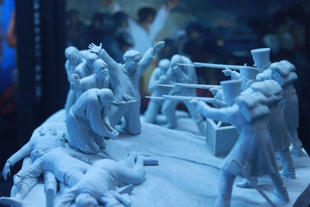 Diorama de miniaturas que representa una escena de batalla con soldados armados y figuras caídas, expuesto en Freak Wars 2026.