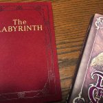 Libros de los juegos de rol de Dentro del Laberinto y The Dark Crystal sobre una mesa de madera.